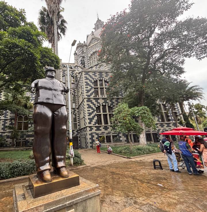 Sculpture de Botero devant un bâtiment historique à damier.