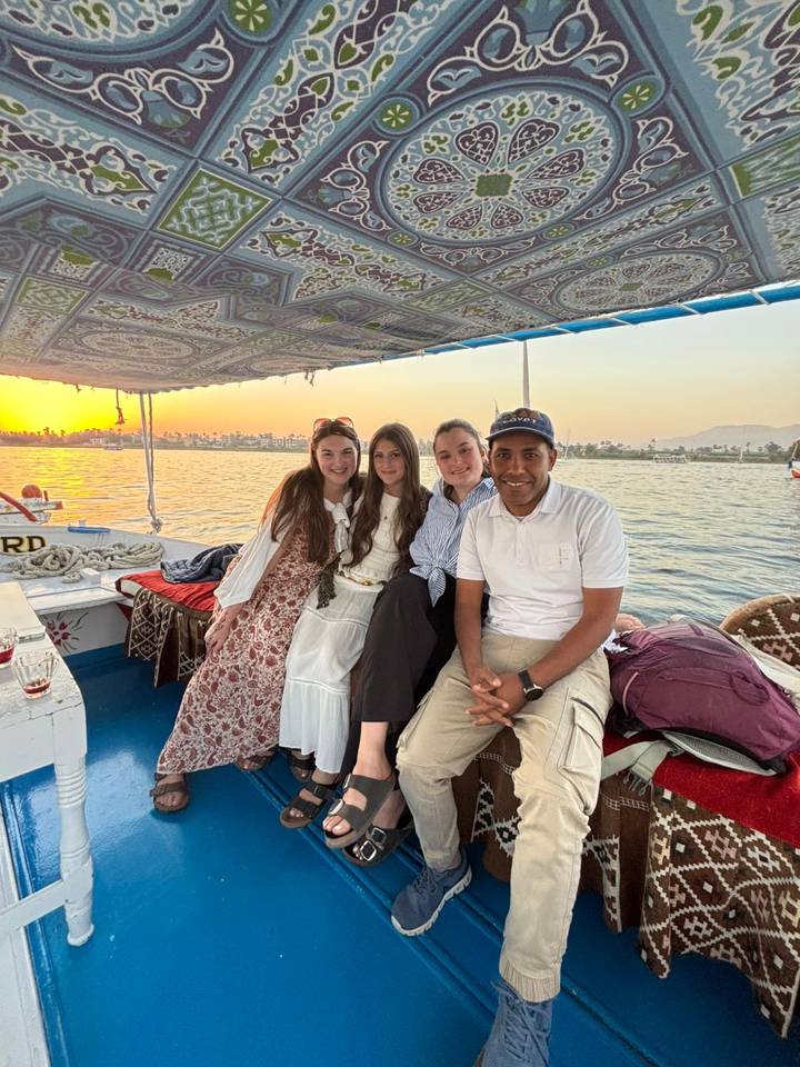 Un grupo de personas en un barco al atardecer.