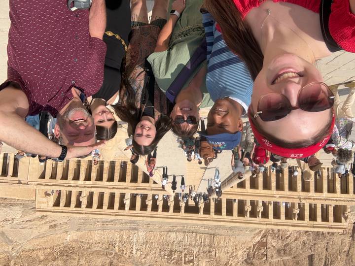 Un grupo de turistas posando en un sitio de templo antiguo.