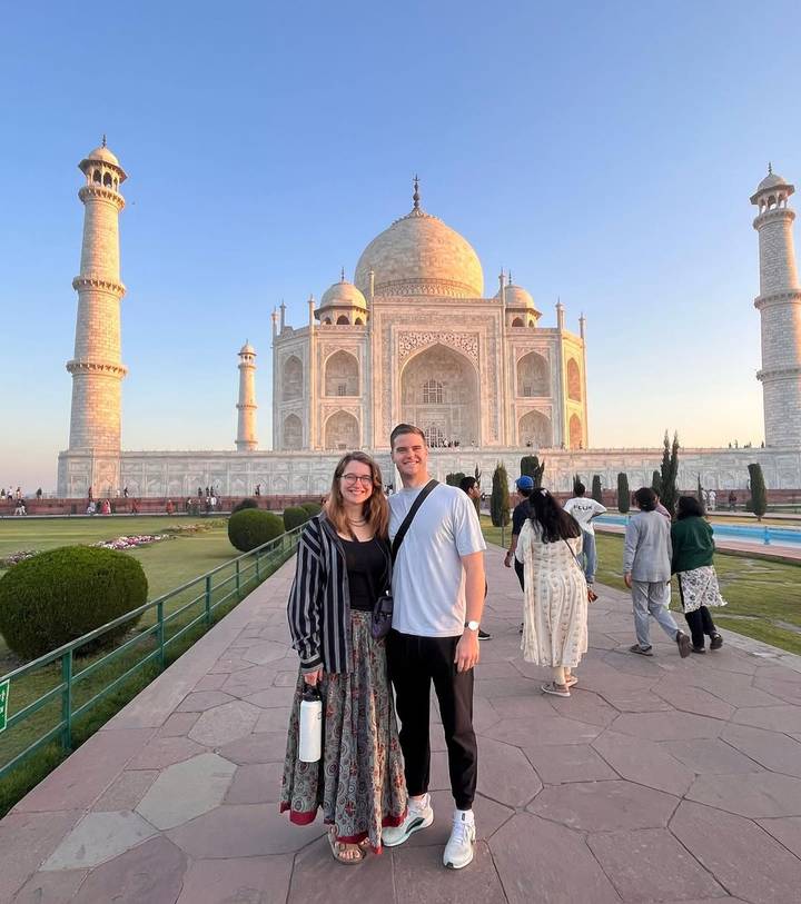 Pareja posando frente al Taj Mahal durante el día.