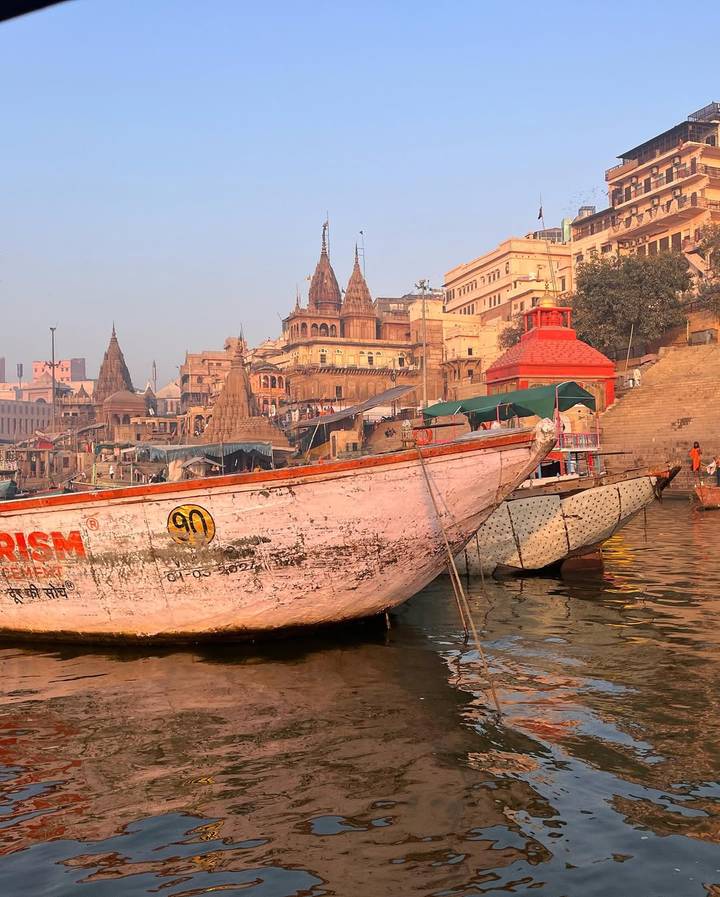 Edificios coloridos en la orilla del río con botes en primer plano.