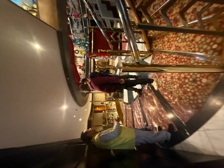 Des personnes debout dans un espace intérieur décoré avec des sols réfléchissants.