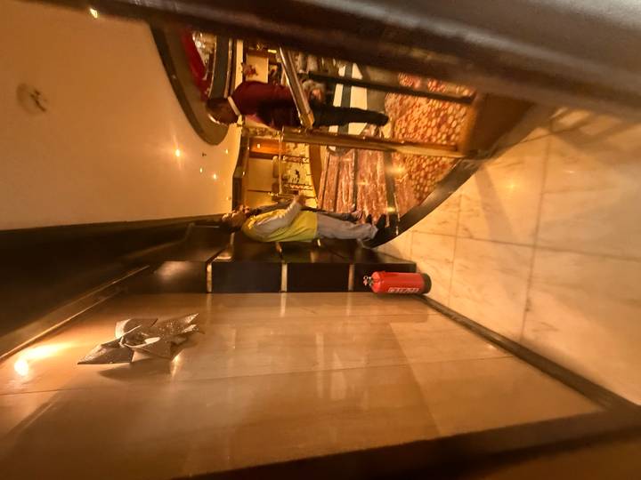 Des personnes conversant dans ce qui semble être un couloir avec des sols en marbre.