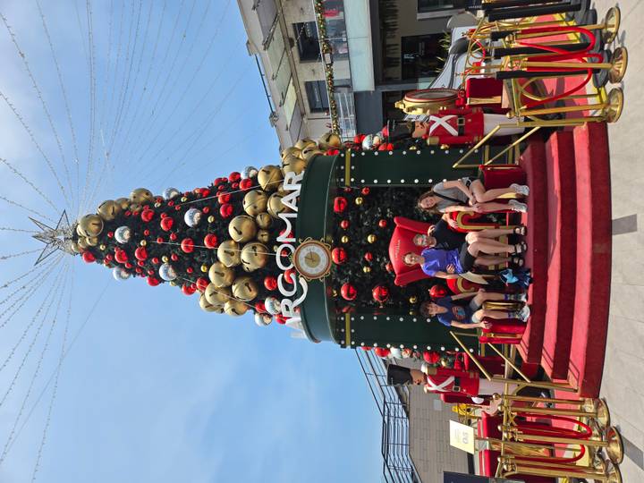 Familia posando frente a una decoración navideña.