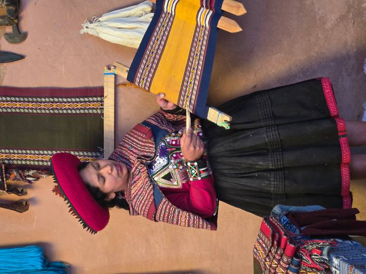 Persona con ropa tradicional tejiendo.