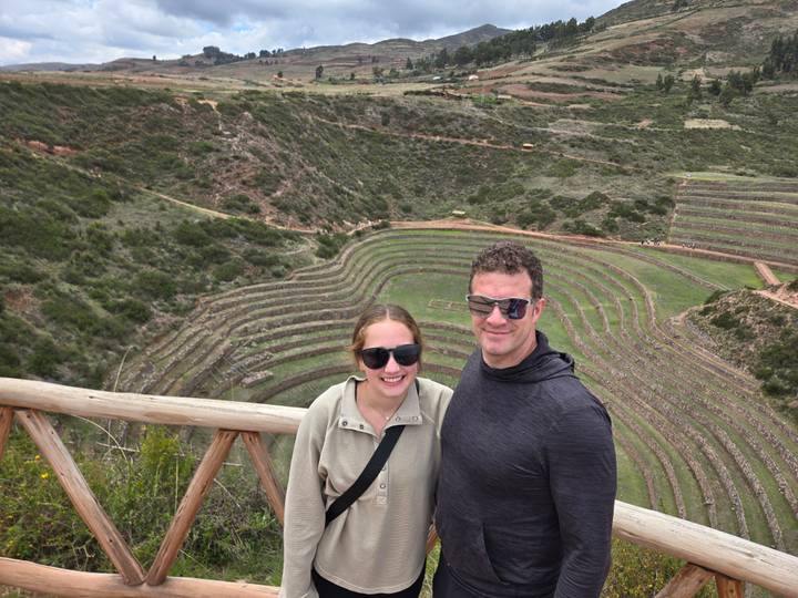Pareja posando frente a terrazas agrícolas.