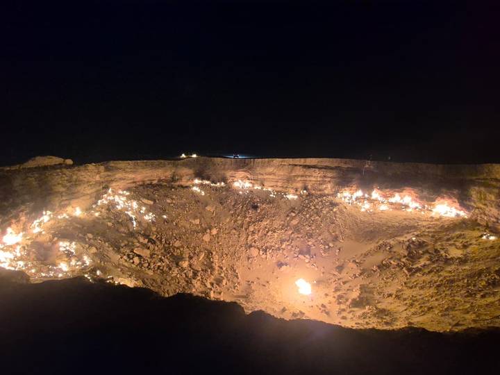 Burning crater with flames visible at night, known as the Gates of Hell.