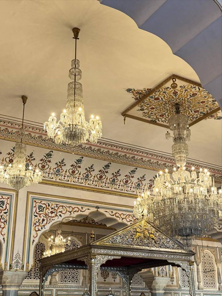 Interior con candelabros de cristal y decoraciones ornamentales del techo.