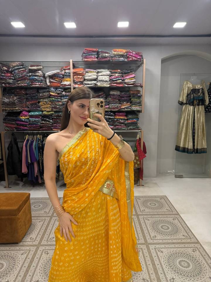 Femme portant un sari jaune prenant un selfie.
