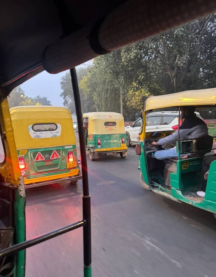 Des auto-rickshaws dans la circulation sur une route de ville.