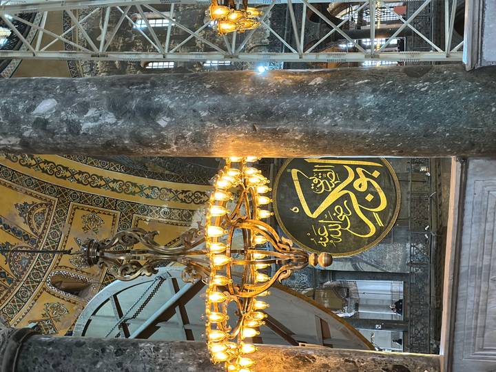 Intérieur d'une mosquée avec des lustres et une décoration ornée.