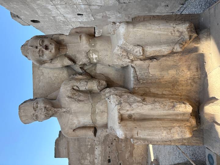 Two seated stone statues of Egyptian figures.