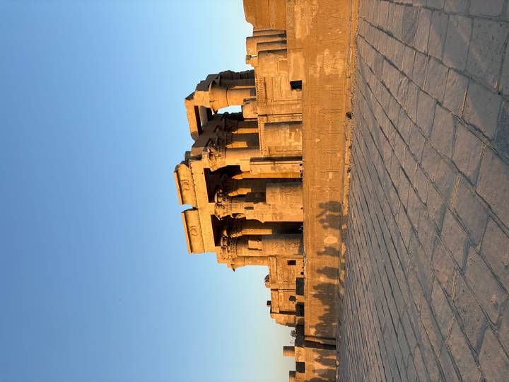 Ancient Egyptian temple with the setting sun casting long shadows.