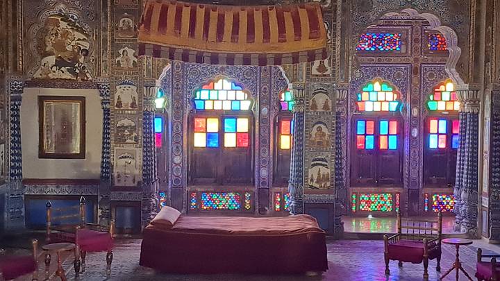 Pièce avec des vitraux colorés et une décoration ornée.