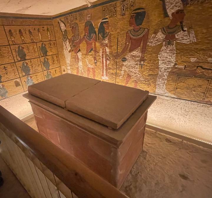 Interior de una tumba antigua con murales jeroglíficos.