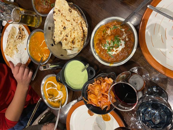 Variedad de platos indios incluyendo currys y naan en una mesa.