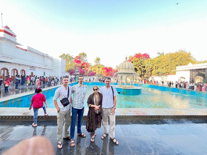 Familia posando frente a una estructura histórica con fuentes.