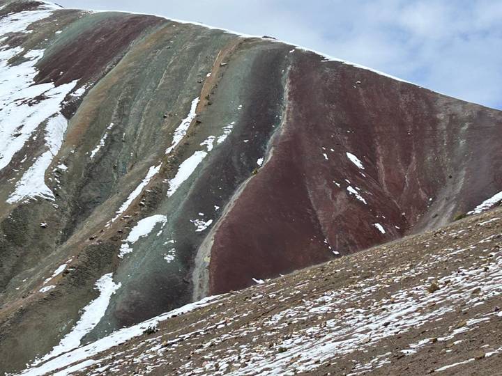 Colorful mountain slopes with patches of snow.