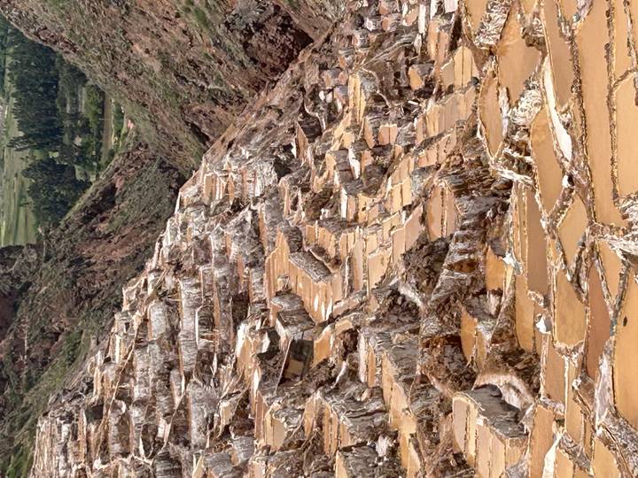 Terraced salt ponds cascading down a mountain valley.