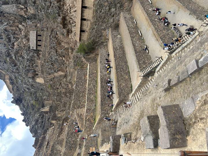 Terraced Incan ruins with visitors exploring.