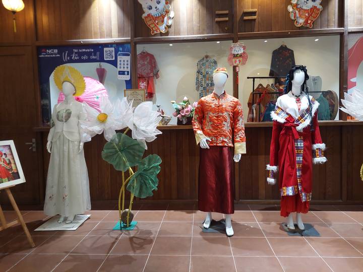 Exhibición de maniquíes con trajes tradicionales en una tienda.