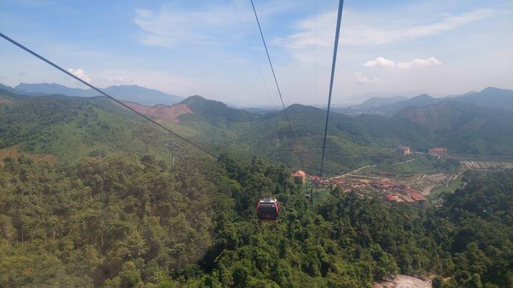 Vista desde un teleférico con vistas a una vasta extensión de vegetación y montañas.