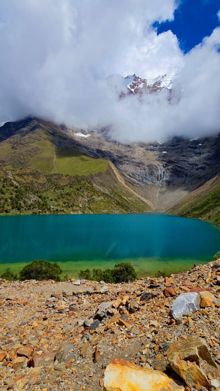 Turquoise mountain lake with surrounding peaks.