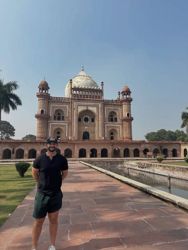 Homme debout devant un monument historique indien.