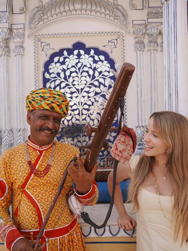 Músico tradicional y turista sonriendo juntos.