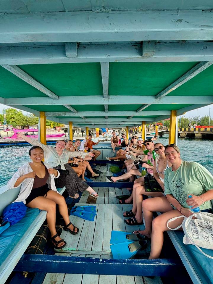 Gente en un paseo en barco, visiblemente alegre.