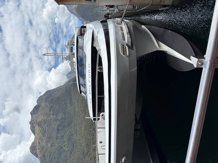 Gros plan d'un bateau moderne avec des montagnes en arrière-plan.