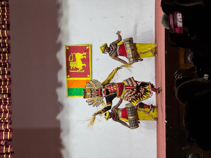 Intérpretes en atuendo tradicional en el escenario durante una danza cultural.