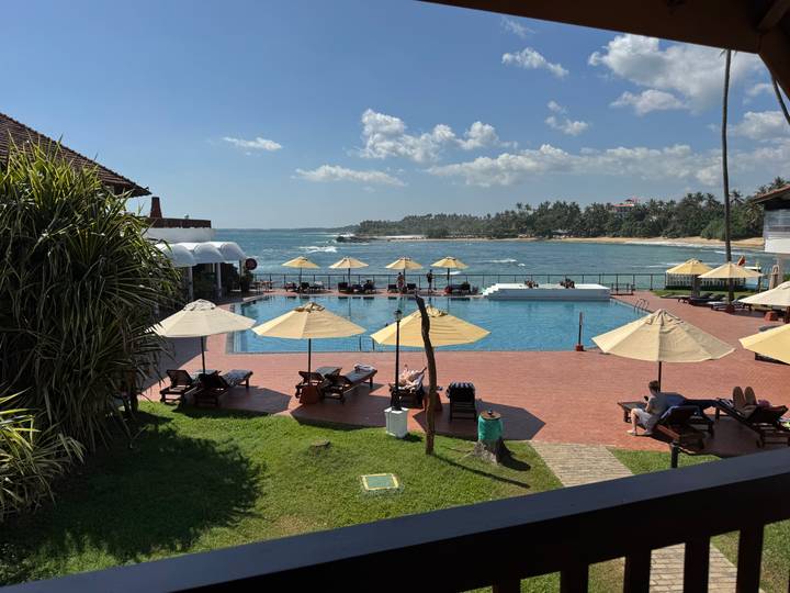 Área de piscina del resort con vista al océano.