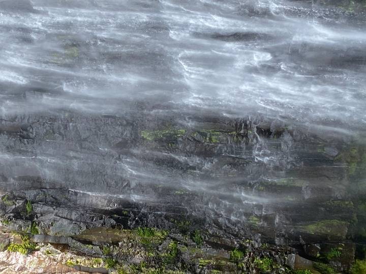 Une portion d'une cascade dévalant des rochers.