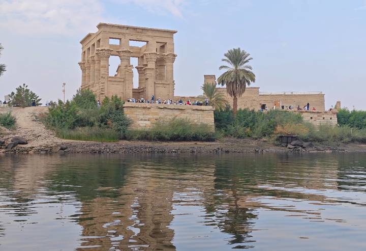 Historical temple ruins by the water, likely in Philae, Egypt.