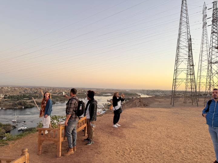 Tourists standing on a hill with transmission towers.