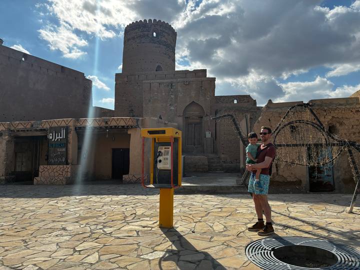 Façade d'un ancien bâtiment avec une personne tenant un enfant.