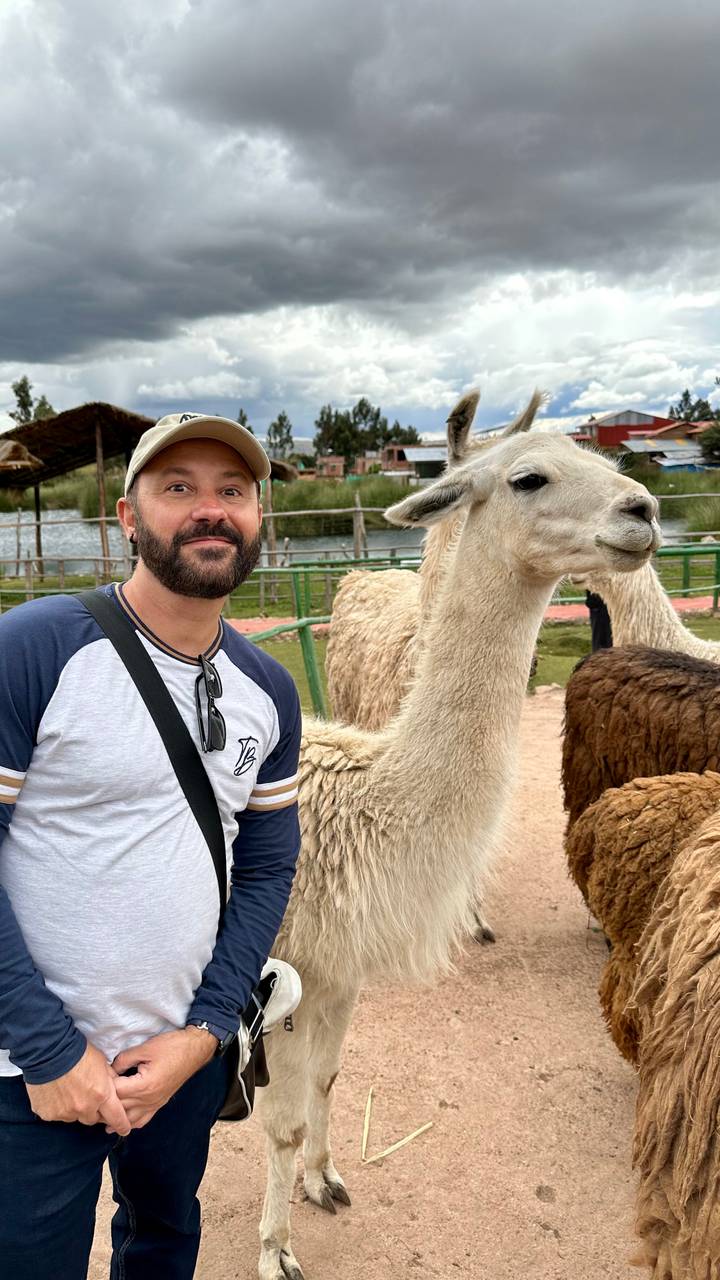 Man posing with llamas.