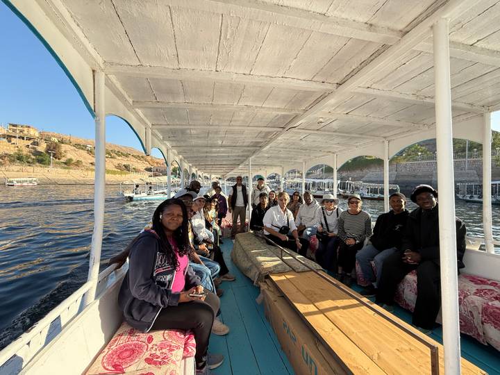 Tourists sitting on a boat enjoying a scenic ride on a river.