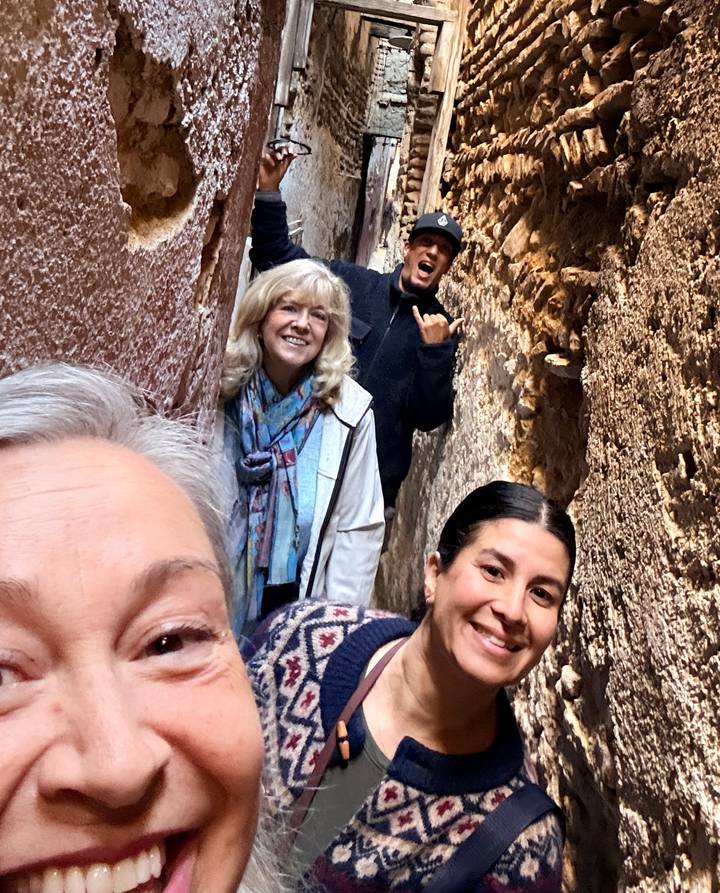 Un groupe de personnes posant dans une ruelle étroite en pierre.