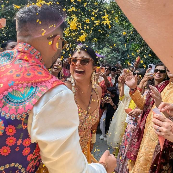 Une cérémonie de mariage indienne avec une foule joyeuse qui lance des fleurs.