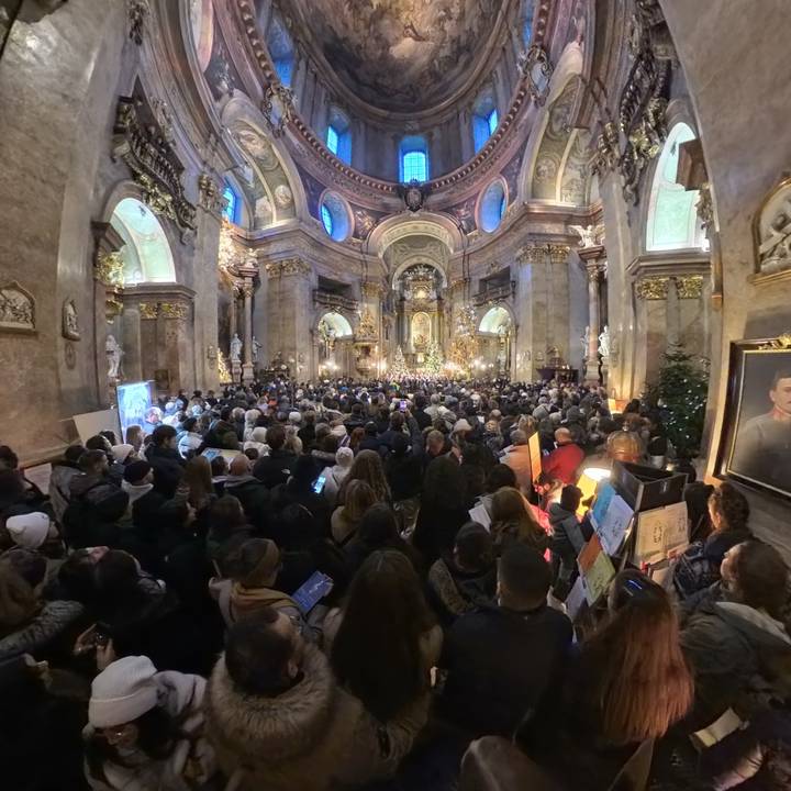Un interior abarrotado de una iglesia histórica con detalles ornamentados.