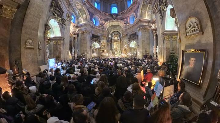 Un interior de iglesia histórica lleno de una gran multitud.