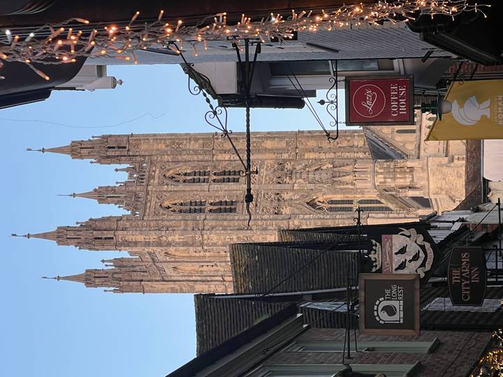 Las torres de la Catedral de Canterbury alzándose sobre una pintoresca calle.