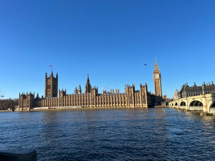 Vista diurna de un gran edificio de estilo gótico junto al río.