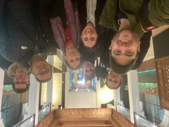 Groupe de personnes posant à l'intérieur avec une décoration ornée.