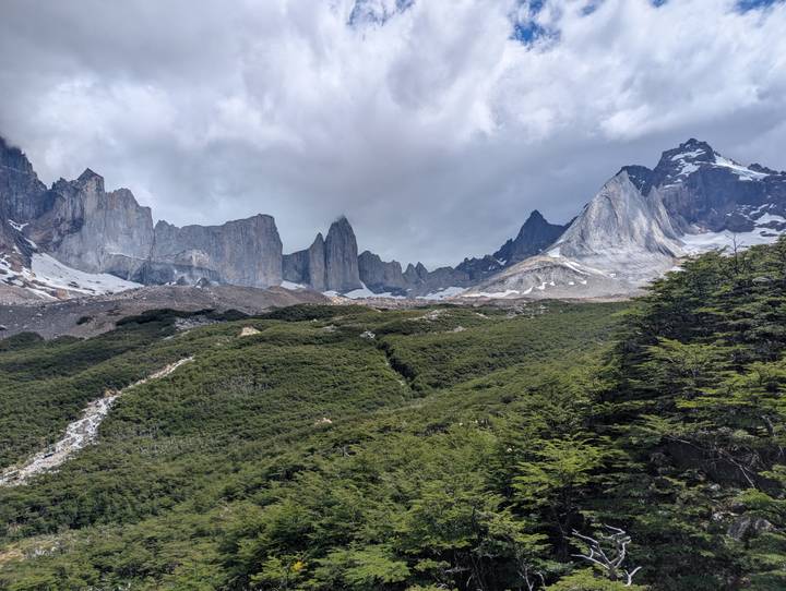 Vista expansiva de cordillera montañosa con picos cubiertos de nieve.