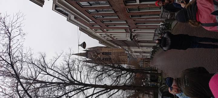 Rue urbaine traditionnelle avec clocher d'église en arrière-plan.