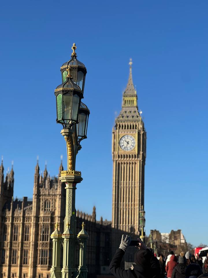 El Big Ben y una farola bajo un cielo azul despejado.