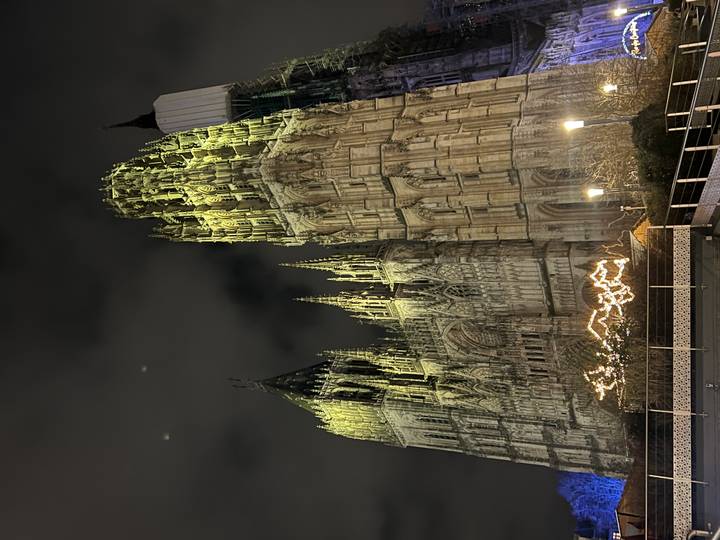 Gran catedral gótica iluminada por la noche.